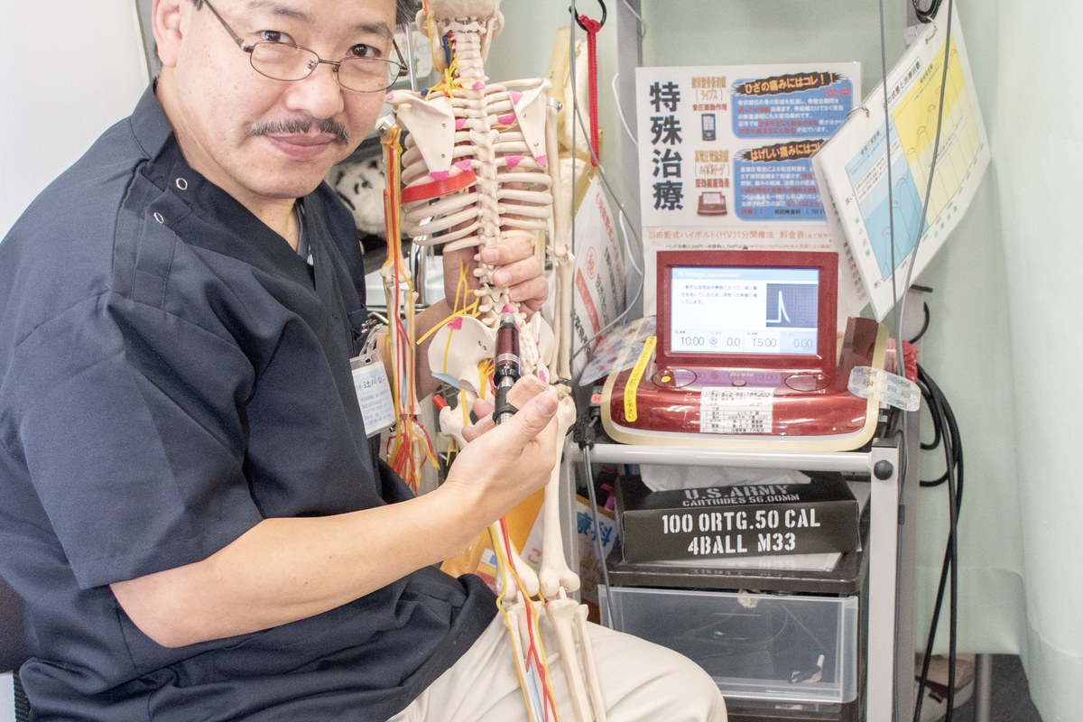 骨格模型を使って原因を説明する院長